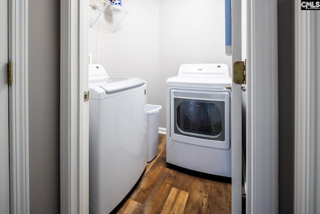 laundry area with washing machine and dryer and dark wood-type flooring