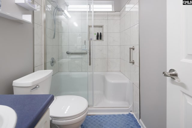 bathroom featuring vanity, toilet, and a shower with door