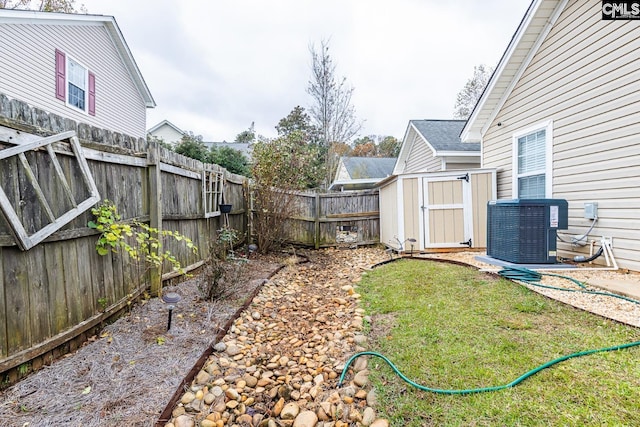 view of yard with central air condition unit and a storage shed