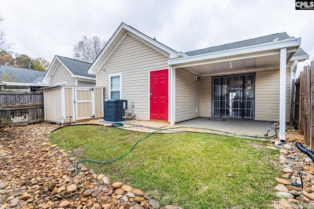 back of property featuring central AC unit, a shed, a yard, and a patio