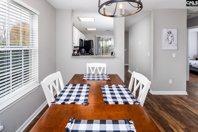 dining space with a chandelier, a textured ceiling, and dark hardwood / wood-style flooring