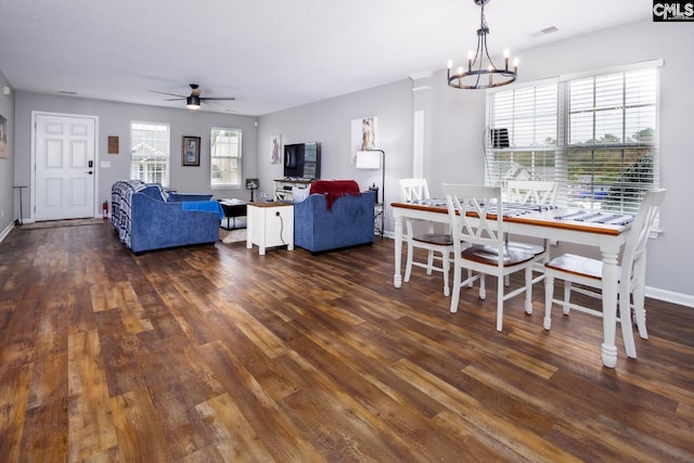 dining area featuring ceiling fan with notable chandelier and dark hardwood / wood-style floors