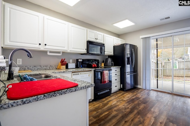 kitchen with dark hardwood / wood-style flooring, white cabinets, black appliances, and sink