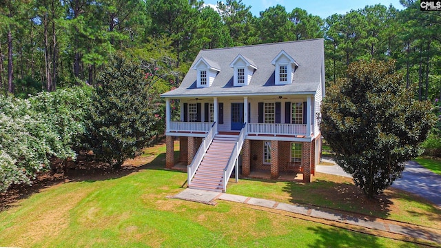 view of front of property with ceiling fan, a porch, and a front lawn