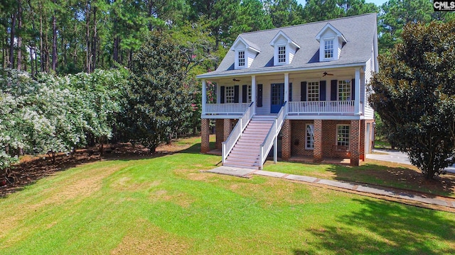 view of front of property featuring ceiling fan, covered porch, and a front yard