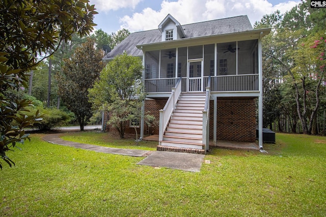 view of front of home featuring a front yard, ceiling fan, and a sunroom