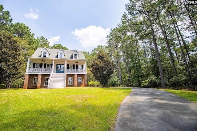 view of front of house with a front yard, a porch, and ceiling fan