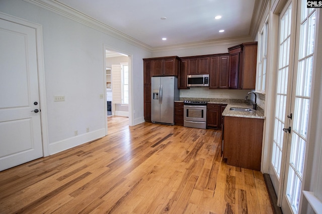 kitchen featuring french doors, crown molding, light hardwood / wood-style floors, light stone counters, and stainless steel appliances