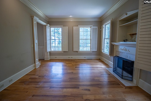 unfurnished living room featuring hardwood / wood-style floors and crown molding