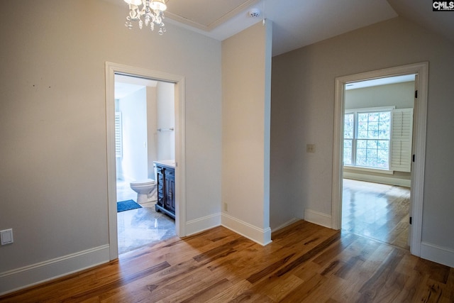 hall featuring hardwood / wood-style floors, vaulted ceiling, and a chandelier