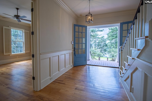 foyer entrance with wood-type flooring, plenty of natural light, and ornamental molding