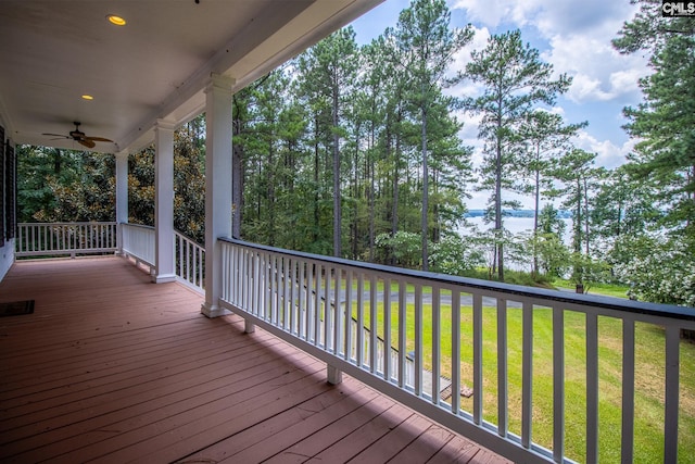 deck with ceiling fan, covered porch, and a yard