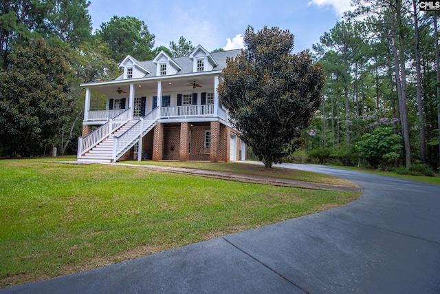 view of front of home with ceiling fan, a porch, a garage, and a front yard