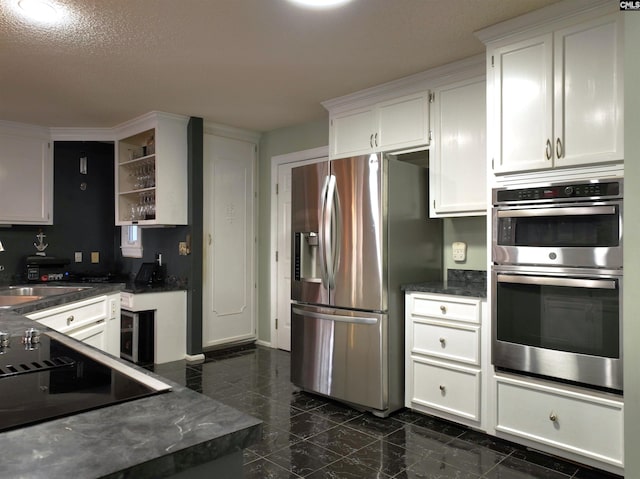 kitchen with white cabinets, appliances with stainless steel finishes, a textured ceiling, and sink