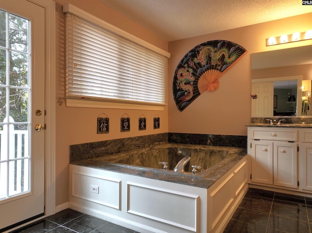 bathroom featuring a bath, a textured ceiling, and vanity