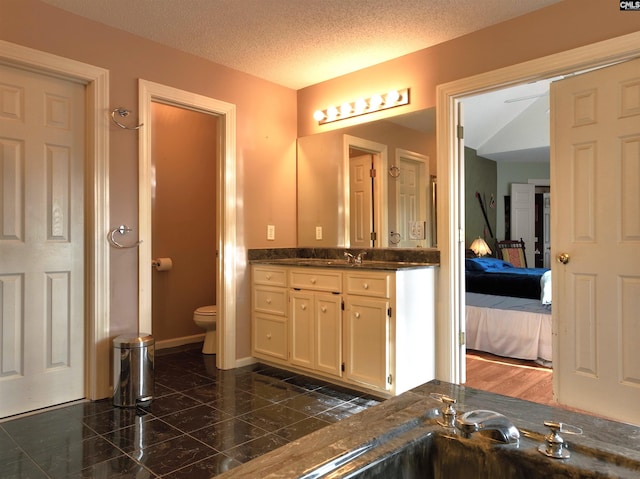 bathroom with vanity, a textured ceiling, and toilet