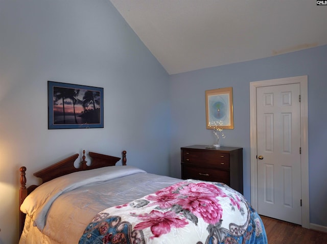 bedroom with dark wood-type flooring and lofted ceiling