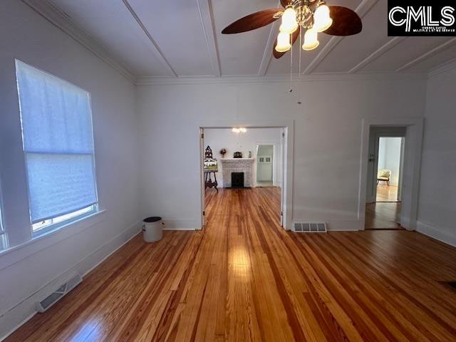 unfurnished room with ceiling fan, wood-type flooring, and ornamental molding