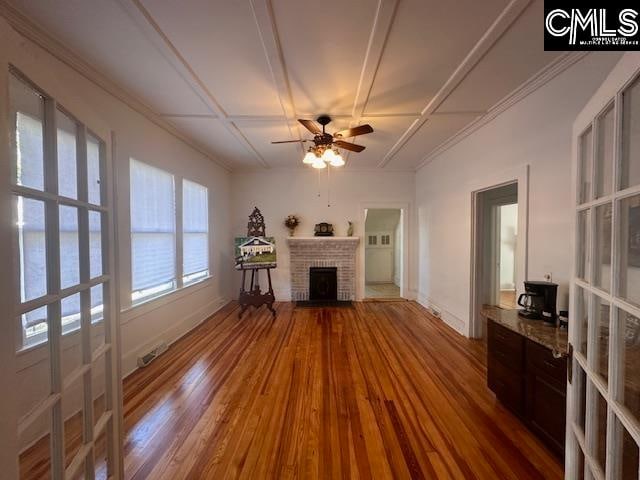 unfurnished living room with ceiling fan, wood-type flooring, a fireplace, and coffered ceiling