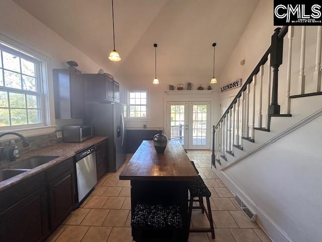 kitchen with a center island, stainless steel appliances, plenty of natural light, and sink