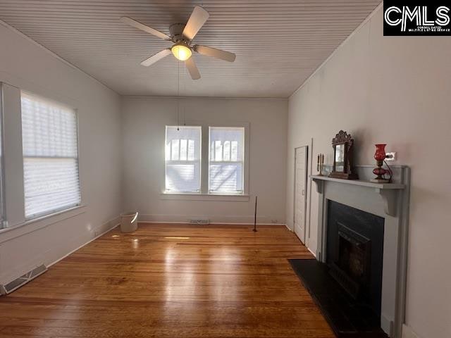 living room with ceiling fan, a healthy amount of sunlight, and wood-type flooring