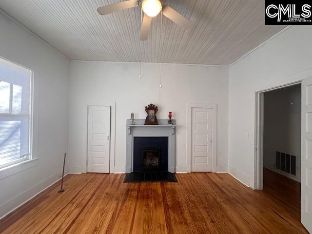 unfurnished living room with ceiling fan and wood-type flooring