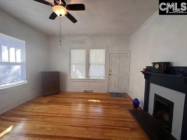 living room featuring ceiling fan, light hardwood / wood-style floors, and crown molding