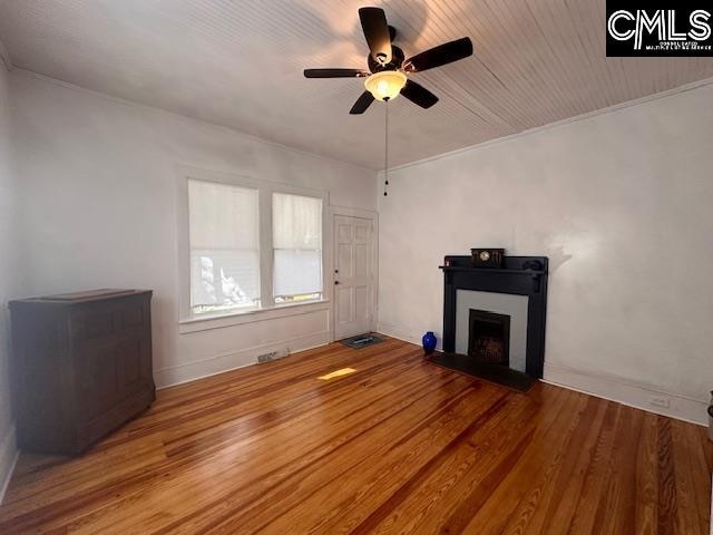 unfurnished living room with wood-type flooring, ceiling fan, and crown molding