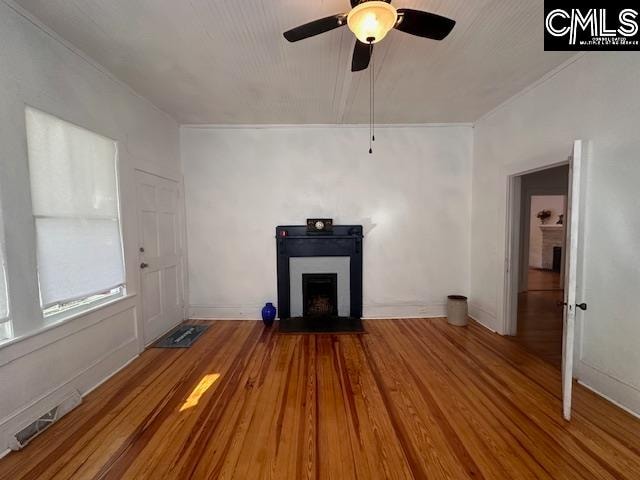 unfurnished living room with hardwood / wood-style floors, ceiling fan, and ornamental molding