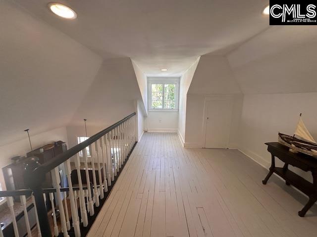 bonus room with hardwood / wood-style floors and lofted ceiling