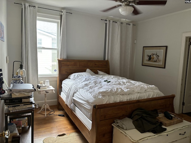 bedroom with ceiling fan, light wood-type flooring, ornamental molding, and multiple windows