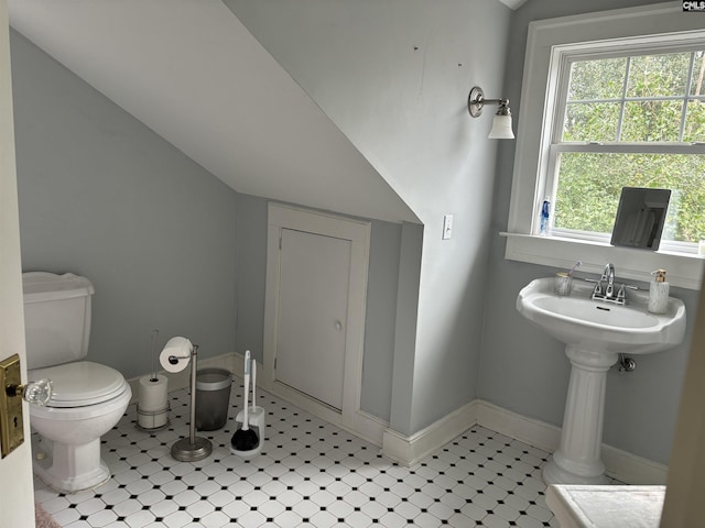 bathroom featuring tile patterned flooring, lofted ceiling, toilet, and a healthy amount of sunlight