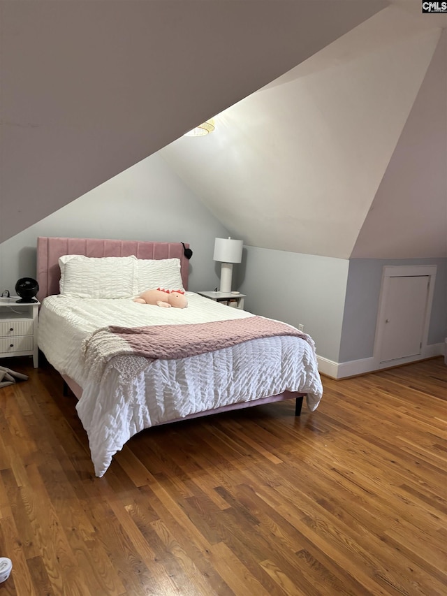 bedroom with vaulted ceiling and hardwood / wood-style flooring