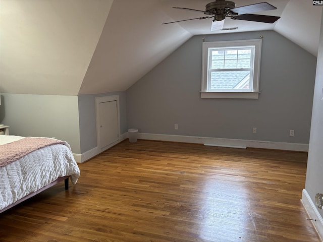 bedroom with ceiling fan, wood-type flooring, and lofted ceiling