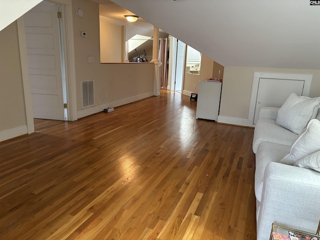 unfurnished living room featuring lofted ceiling and wood-type flooring