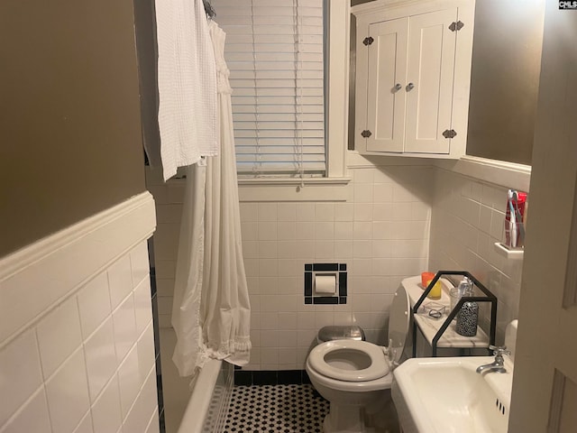 full bathroom with sink, shower / bath combo, tile patterned flooring, toilet, and tile walls