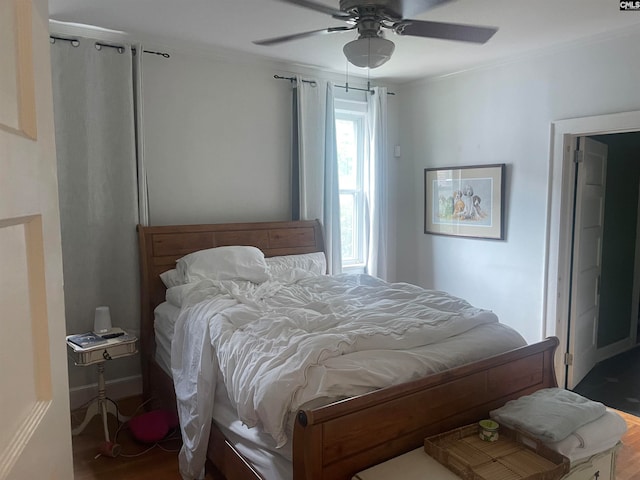 bedroom featuring hardwood / wood-style flooring, ceiling fan, and crown molding