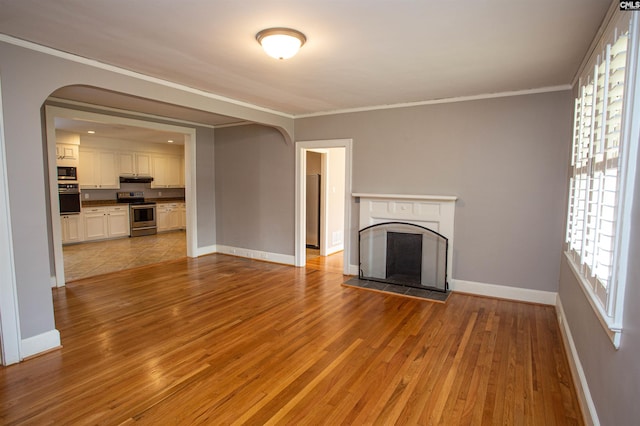 unfurnished living room with light wood-type flooring and ornamental molding