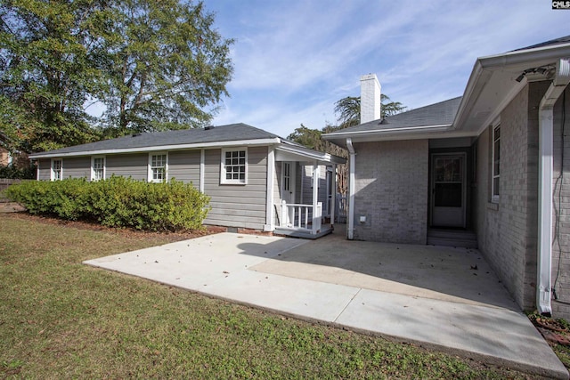 rear view of house featuring a yard and a patio area