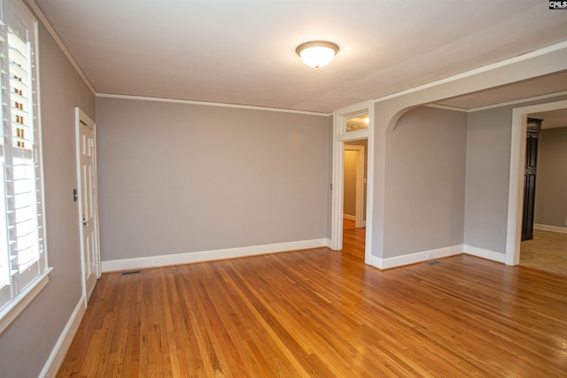 spare room featuring hardwood / wood-style floors and crown molding