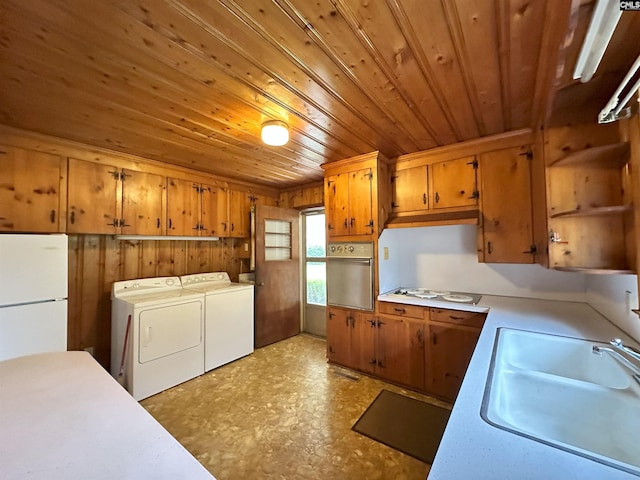 kitchen with washer and clothes dryer, stainless steel oven, wooden ceiling, white refrigerator, and sink