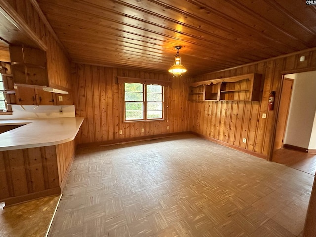 unfurnished living room with wood walls, wooden ceiling, and parquet flooring