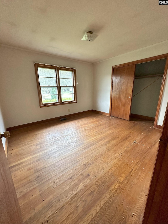 unfurnished bedroom featuring a closet and light wood-type flooring