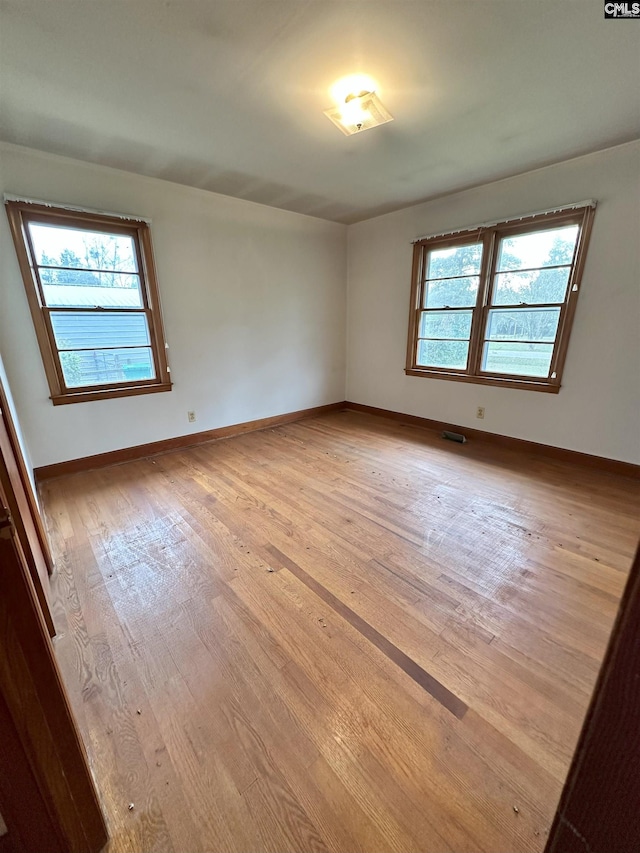 unfurnished room featuring plenty of natural light and light hardwood / wood-style floors