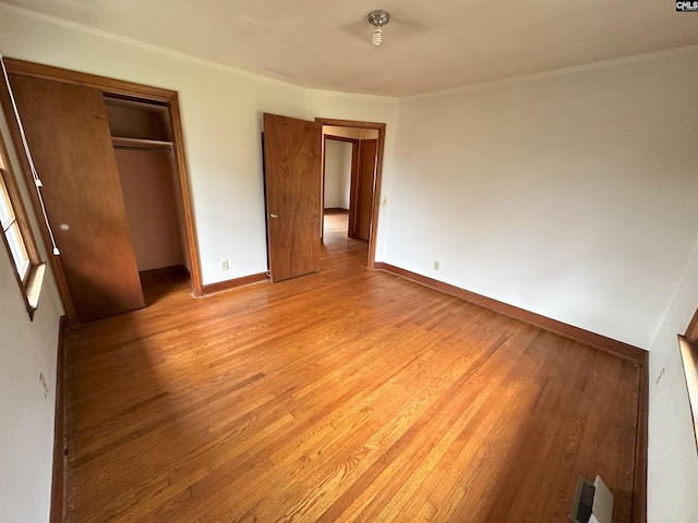 unfurnished bedroom with light hardwood / wood-style floors and a closet