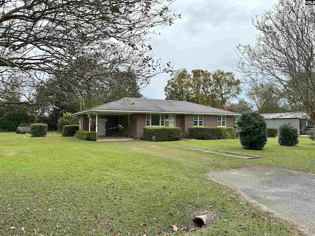 ranch-style house featuring a front lawn and a carport