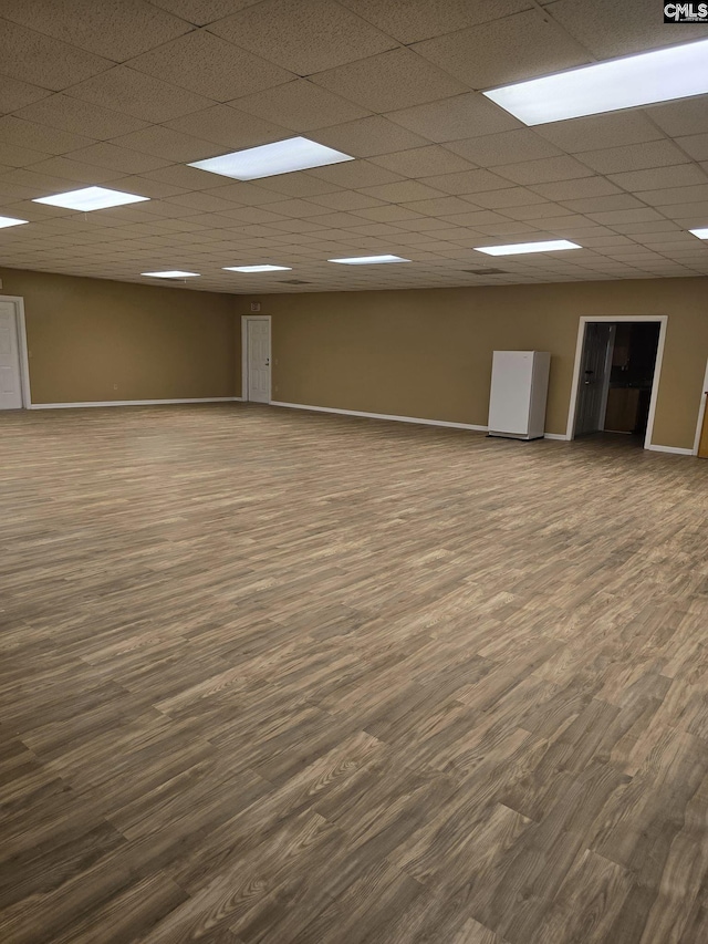 empty room featuring a drop ceiling and hardwood / wood-style flooring