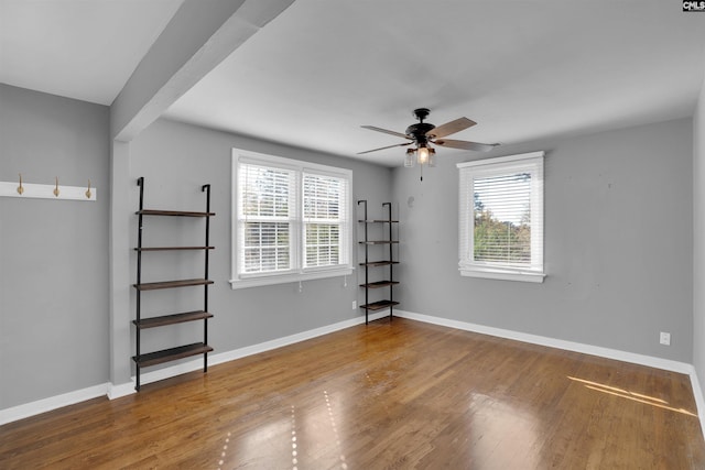 empty room with ceiling fan and hardwood / wood-style flooring