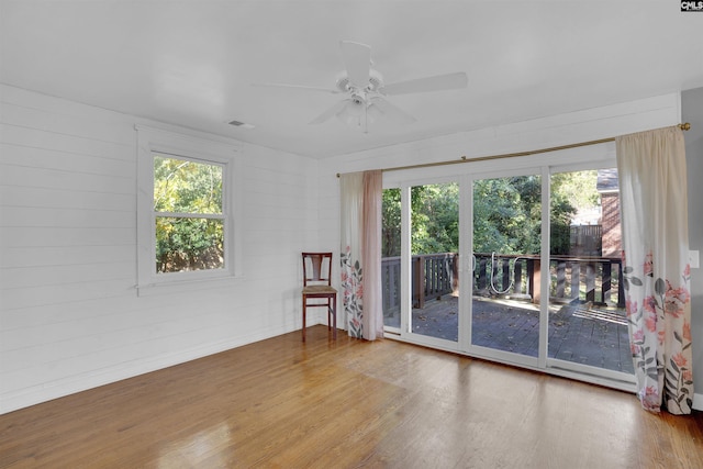 empty room featuring hardwood / wood-style flooring, a wealth of natural light, and ceiling fan