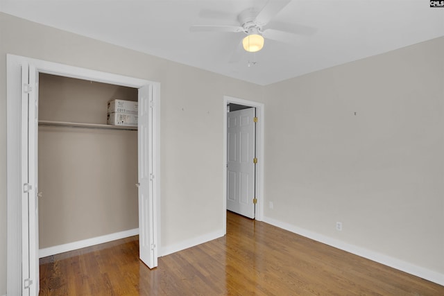 unfurnished bedroom featuring a closet, hardwood / wood-style flooring, and ceiling fan